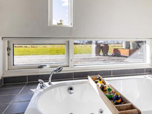 La salle de bains est pourvue d'une baignoire et d'une fenêtre. dans l'établissement Holiday home Gedser XIX, à Gedser