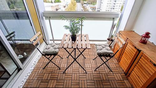 balkon z 2 krzesłami, stołem i rośliną w obiekcie Logement entier proche de Lyon w mieście Vénissieux