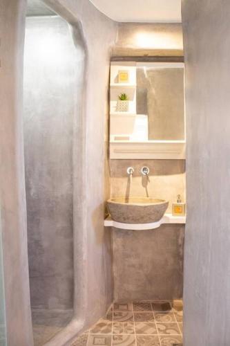 a bathroom with a sink and a mirror at Traditional Arch House Paros in Márpissa