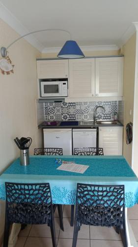 une cuisine avec un comptoir bleu dans l'établissement BLEU MARINE Vue sur l'Océan, à Lacanau-Océan