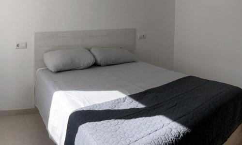 モライラにあるMoraira Holiday Apartmentのベッドルーム(白いベッド、黒い毛布付)