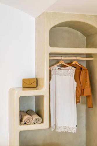 a closet with a white dress and towels at Marvarit Suites in Mesaria