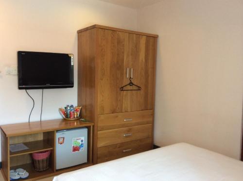 a bedroom with a wooden cabinet and a tv at Co Ba Vung Tau Hotel in Vung Tau