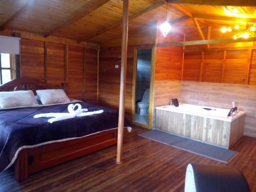 Una cama o camas en una habitación de HOTEL CABAÑAS SANTO TOMAS