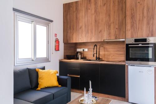 ein Wohnzimmer mit einem Sofa und einer Küche in der Unterkunft Royal Stay Luxury Homes in Paphos City