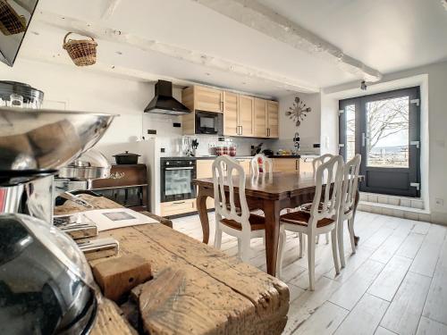 une cuisine avec une table et des chaises en bois dans l'établissement Bâtisse de charme et vue exceptionnelle entre Causses et Gorges du Tarn, à Saint-Rome-de-Dolan