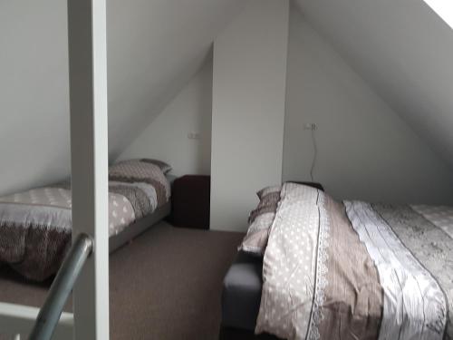 a bedroom with two beds in a attic at Prins van Poederoijen in Poederoijen