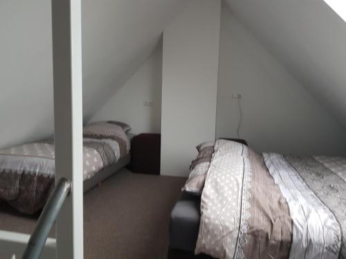 um quarto com 2 camas num sótão em Prins van Poederoijen em Poederoijen