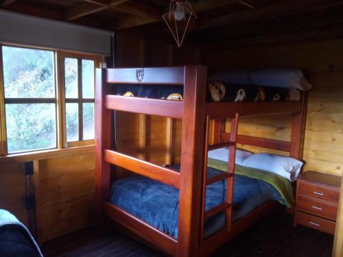 1 dormitorio con literas en una cabaña de madera en HOTEL CABAÑAS SANTO TOMAS, en Paipa