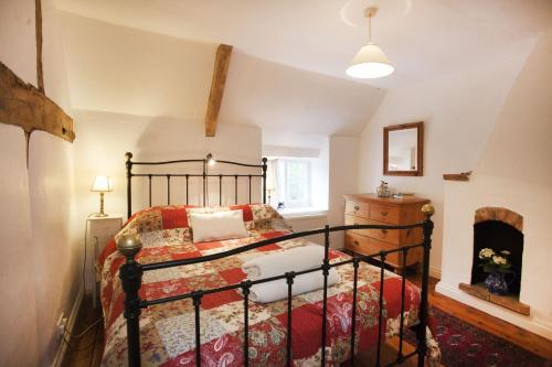 een slaapkamer met een bed en een open haard bij Honey Barrel Cottage in Stiffkey