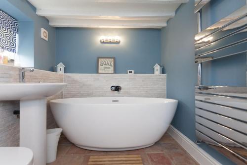 Barney的住宿－Harvey Cottage，浴室配有白色浴缸和水槽