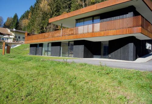 a building on the side of a hill with a grass field at Apartment GIDI und LISL in Bramberg am Wildkogel