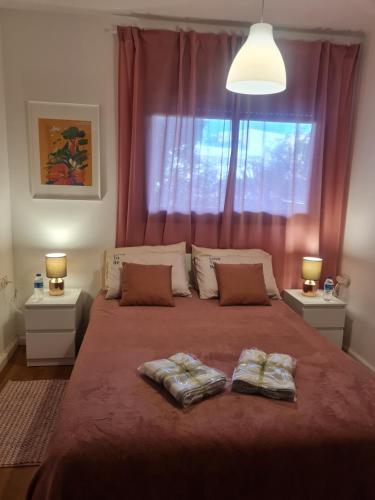 ein Schlafzimmer mit einem großen Bett mit zwei Kissen darauf in der Unterkunft A Dream Place in Raanana, Spacious & Luxurious Apartment up to 4 guests - Swimming Pool in Ra‘ananna