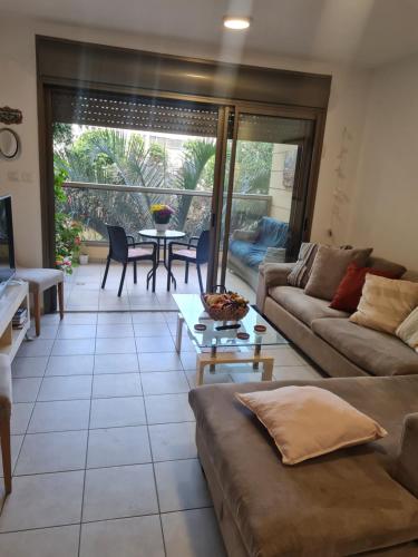 ein Wohnzimmer mit einem Sofa und einem Tisch in der Unterkunft A Dream Place in Raanana, Spacious & Luxurious Apartment up to 4 guests - Swimming Pool in Ra‘ananna