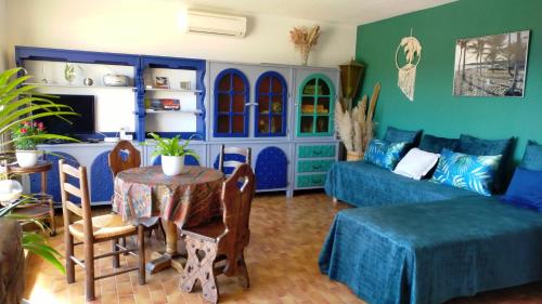 un salon avec un canapé bleu et une table dans l'établissement Grand T2 Luxe Classé 4**** - Plein sud et très calme au Lavandou, au Lavandou