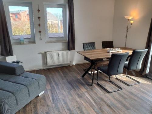 sala de estar con mesa, sillas y sofá en Landruhe, en Strukkamp auf Fehmarn
