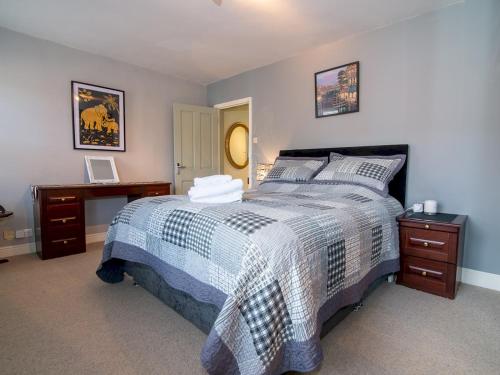 a bedroom with a bed with a blue and white comforter at Pass the Keys Elegant Home near Cotswolds in Evesham