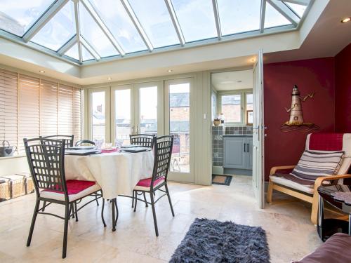 a dining room with a table and chairs and windows at Pass the Keys Elegant Home near Cotswolds in Evesham