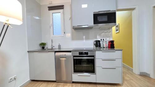 a kitchen with white cabinets and a stove top oven at New Camp Nou Apartment/Diret Airport,Beautiful in Hospitalet de Llobregat