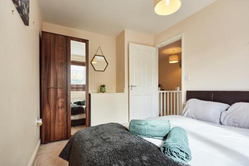 a bedroom with a white bed with a wooden headboard at A modern home away from home in Killingbeck