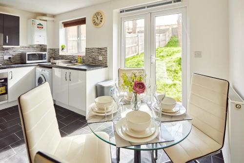 a dining room with a glass table and chairs at A modern home away from home in Killingbeck