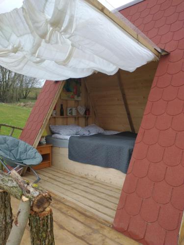 a bed in a wooden house with a roof at Altana letnia nr1 - Herbergerówka Agroturystyka na wsi in Duszniki Zdrój