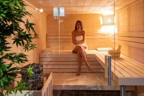 a woman sitting on the inside of a sauna at La Clé du Bonheur sauna jacuzzi hammam massages 