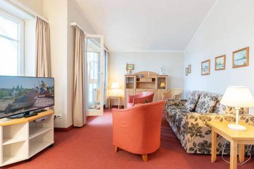 ein Wohnzimmer mit einem Sofa und einem TV in der Unterkunft Fewo 388, Seepark Sellin in Ostseebad Sellin