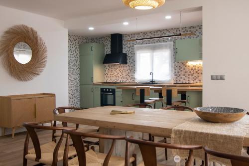 a kitchen and dining room with a wooden table and chairs at La Lagunilla Golf in Candeleda