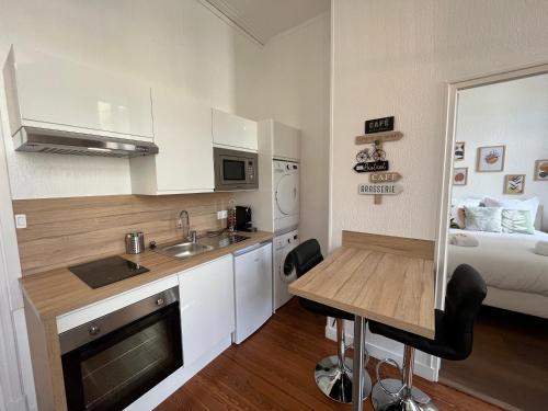 - une petite cuisine avec une table et un lit dans l'établissement Paon, Coquet appt avec parking à Caen, à Caen
