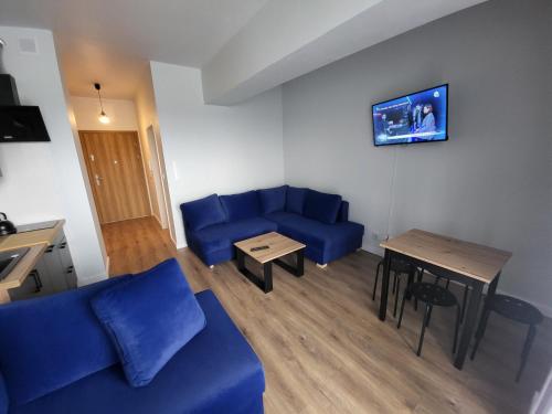 a living room with a blue couch and a table at Nest Niebieski in Zator
