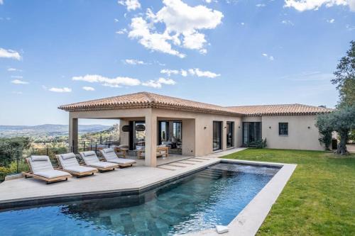 une maison avec une piscine et des chaises longues dans l'établissement Villa Carpe Diem, à Grimaud