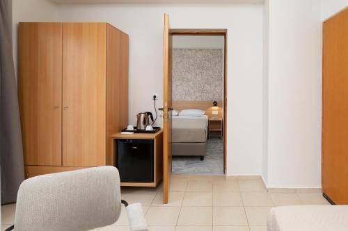 a room with a bedroom with a bed and a chair at Emi Seaside in Amoudara Herakliou