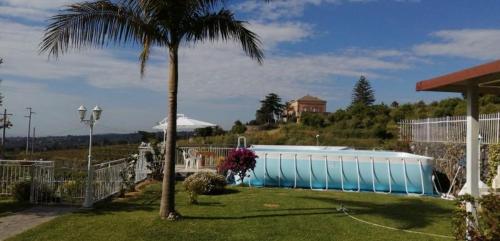 a swimming pool with a palm tree in a yard at Ai tre archi in Mascali