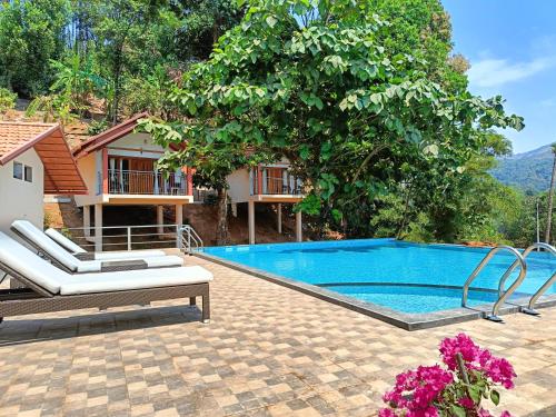 a pool with two lounge chairs next to a house at Hill Crest Resort - Coorg in Madikeri