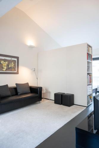 a living room with a couch and a book shelf at Designflats Gent in Ghent