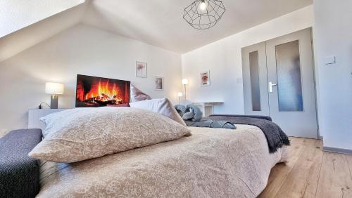科爾馬的住宿－Colmar Mon Amour-CHIC-GARAGE-FIBRE-RBNB，一间白色卧室,配有一张带壁炉的床