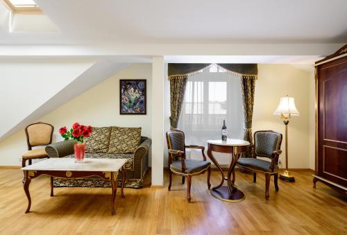 a living room with a couch and a table and chairs at Residence Romanza in Mariánské Lázně