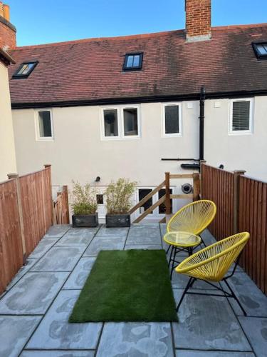a patio with two chairs and a house at Luxury 2 bed cottage in the centre of Melbourne in Melbourne