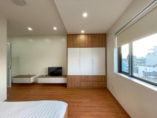 1 dormitorio con 1 cama, TV y ventana en NINE HOUSING 92 Dao Tan en Hanói