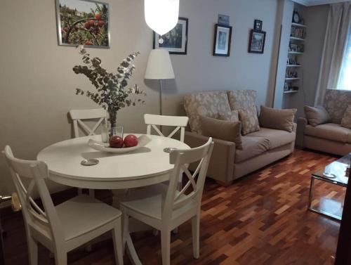 sala de estar con mesa, sillas y sofá en Centro-GASCONA con terraza, garaje y wifi gratuito, en Oviedo