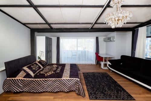 a bedroom with a large bed and a chandelier at 8 Rooms House in Balcova