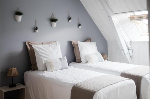 2 camas blancas en una habitación con ventana en Le Moulin des Forges en Sainte-Suzanne