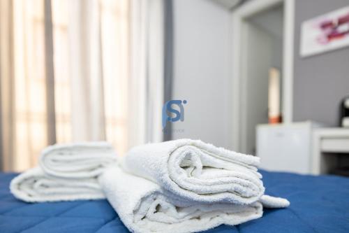 a pile of towels sitting on top of a bed at Il Vittoria - Self Check in in Lascari