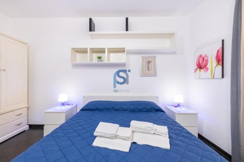 a bedroom with a blue bed with towels on it at Il Vittoria - Self Check in in Lascari