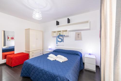 a bedroom with a blue bed with towels on it at Il Vittoria - Self Check in in Lascari