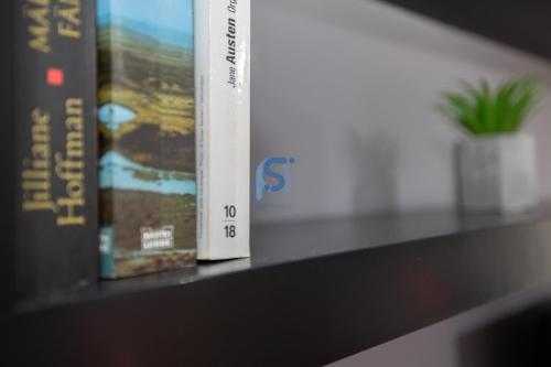 two books are sitting on a shelf at Il Vittoria - Self Check in in Lascari