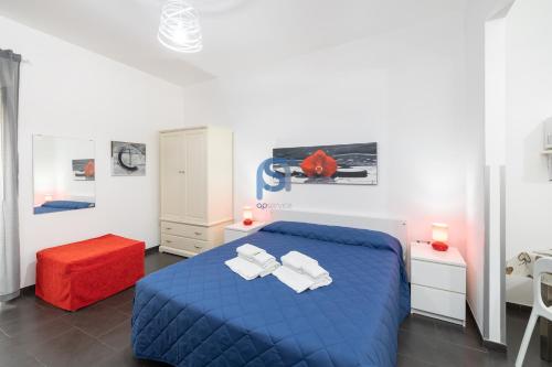 Un dormitorio con una cama azul y un taburete rojo en Il Vittoria - Self Check in, en Lascari
