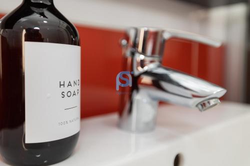 a bottle of wine sitting on a counter next to a sink at Il Vittoria - Self Check in in Lascari