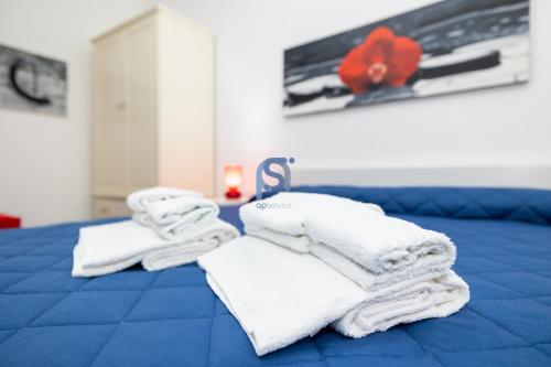 a pile of towels sitting on top of a bed at Il Vittoria - Self Check in in Lascari